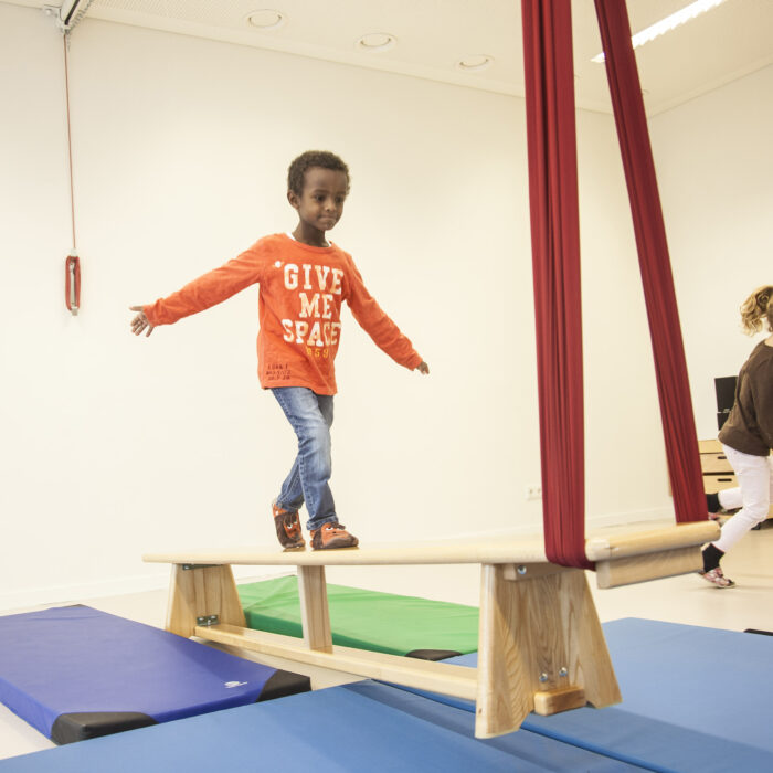 Foto: Kind im Turnsaal macht Übung mit Erlebnistuch von Le Bonbond