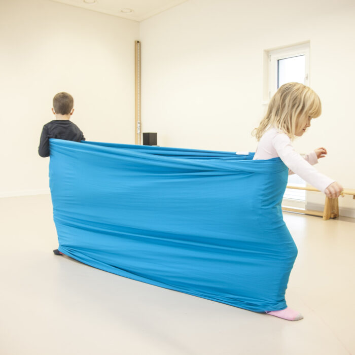 Foto: Kinder im Turnsaal machen Übung mit Erlebnistuch