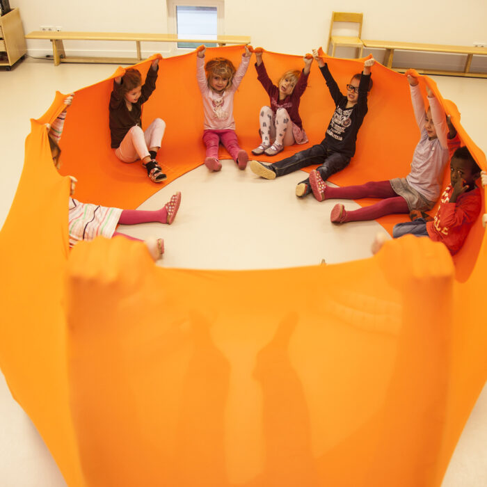 Foto: Kinder im Turnsaal machen Übung mit Erlebnistuch von Le Bonbond