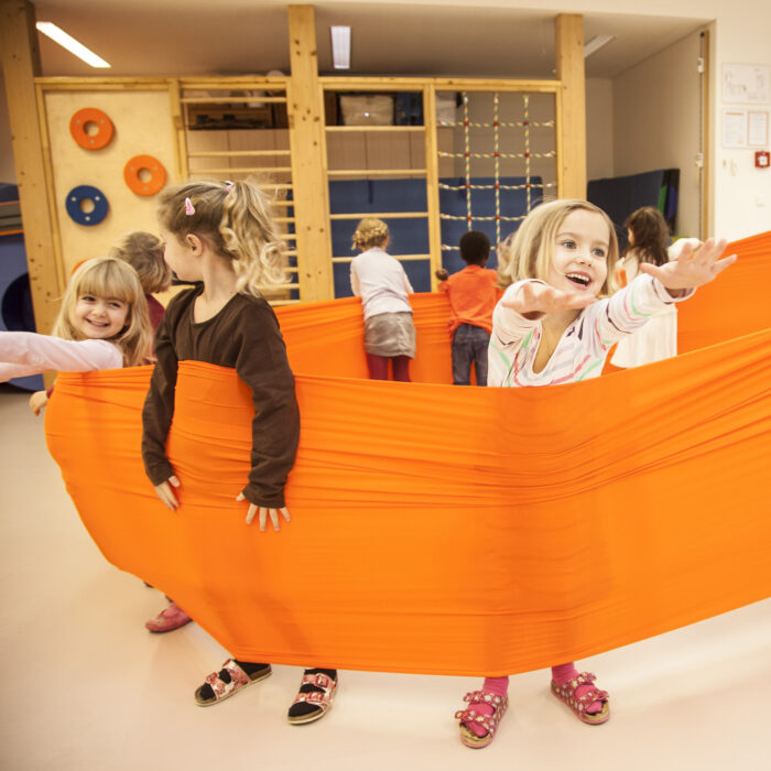 Foto: Kinder im Turnsaal machen Übung mit Erlebnistuch von Le Bonbond