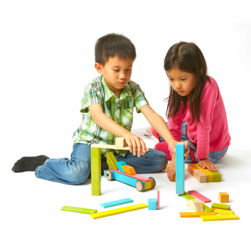 Zwei Kinder spielen mit den tegu Magnetbausteinen aus Holz