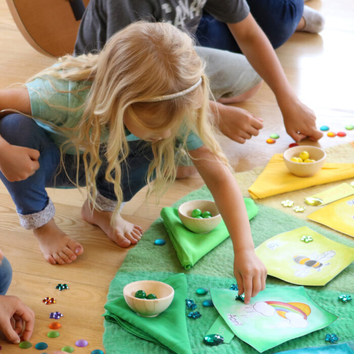 Kind beim Zuordnen von Funkelsteine zu den Farben des Farbenkreises.