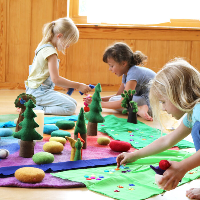 Kinder beim Rollenspiel mit dem Farbenkreis und anderen Filzmaterialien.