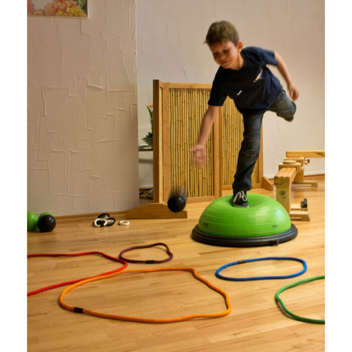 Kind spielt Bewegungsspiel mit Regenbogenseilen