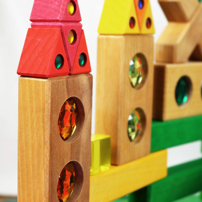 Bauwerk aus Holzbausteinen mit bunten Funkelsteinen aus dem Farbenstraße Baukasten von Bauspiel