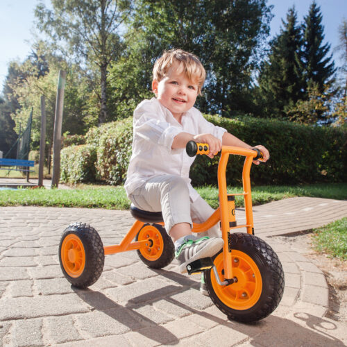 Bub im Krippenalter sitzt auf dem kleinen Dreirad von beleduc, das mit der geringen Sitzhöhe speziell für junge Kinder ab 2 Jahren geeignet ist und mit dem man ideal das Treten von Pedalen erlernen kann.