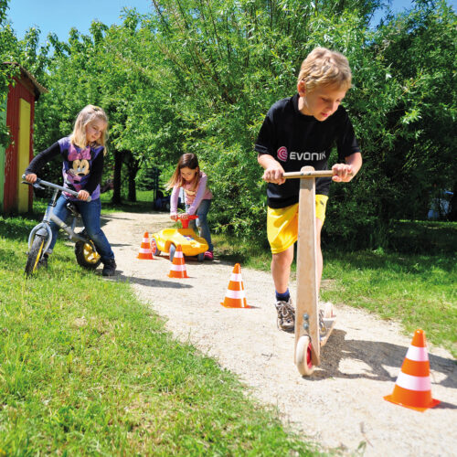 Kinder fahren einen Parcour mit Markierungskegeln