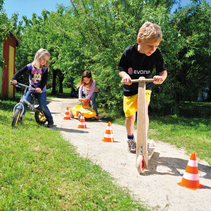 Kinder fahren einen Parcour mit Markierungskegeln