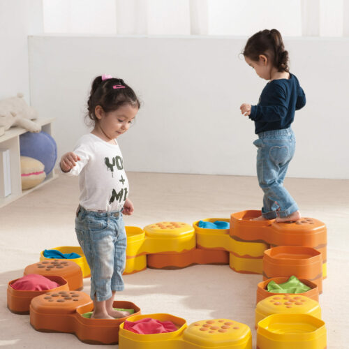 Kinder gehen auf Wabensteinen befüllt mit sensorischem Material