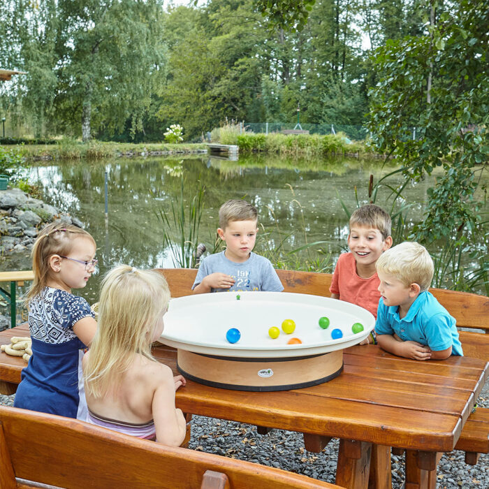 Kinder spielen mit Auflegerwane und Kugeln