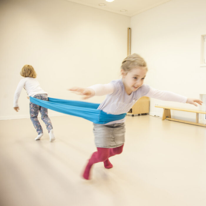 Foto: Kinder im Turnsaal machen Übung mit Erlebnistuch