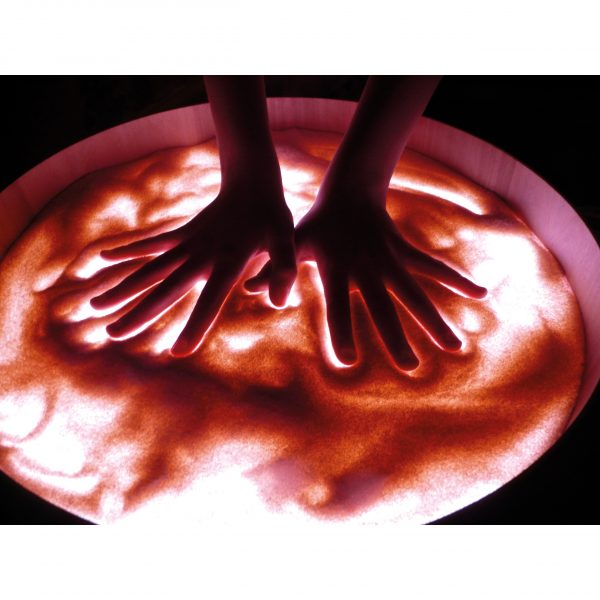 Foto: Hände verstreichen Gries auf beleuchteter Leuchttonne