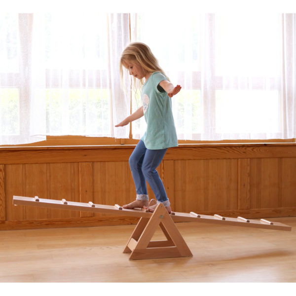 Kindergartenkind balanciert über Laufwippe