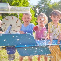 Kinder spielen mit dem mobilen Wasserspielplatz Wellenspieler