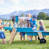 Kinder spielen mit dem mobilen Wasserspielplatz für Krippenkinder