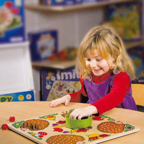 Ein Kind spielt das Gesellschaftsspiel Mecki & Co von Beleduc aus Holz für den Kindergarten