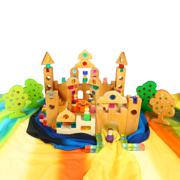 Märchenschloss gebaut aus Holzbausteinen und Glitzersteinen auf einer Landschaft aus Chiffon-Seidentüchern für Kinder im Kindergartenalter