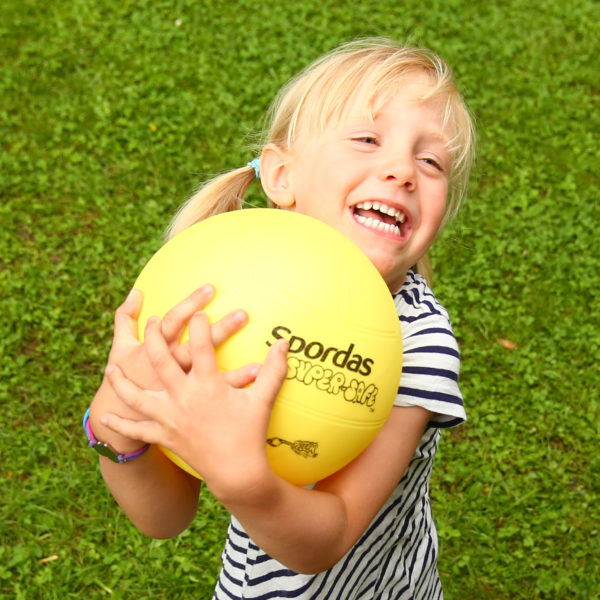 Kind fängt gelben Turnball mit beiden Händen