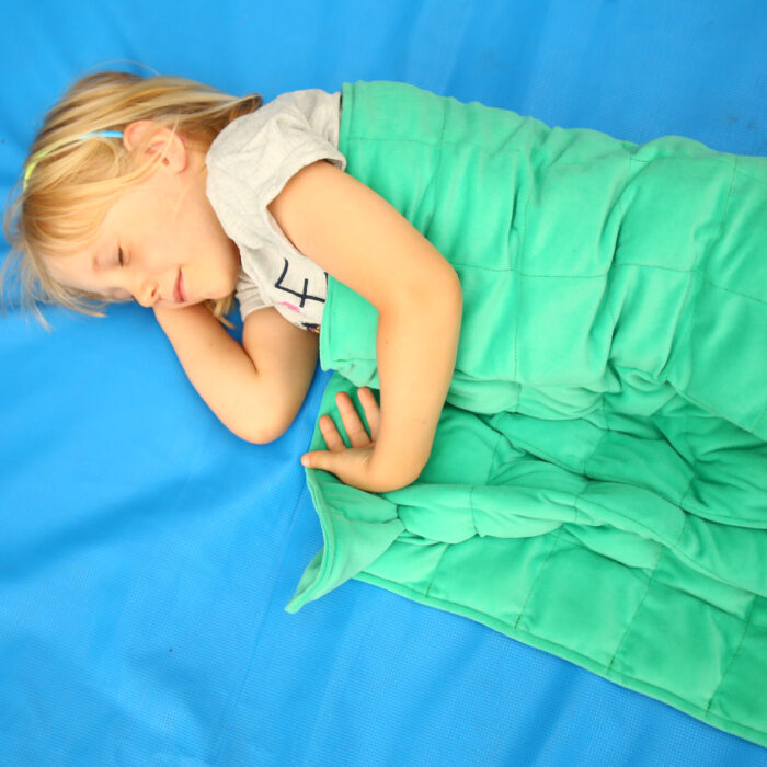 Kindergartenkind entspannt mit Gewichtsdecke