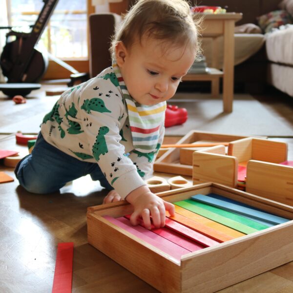 Kind spielt mit bunten Brettchen von Bauspiel