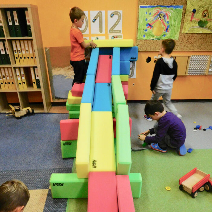 Kindergartenkinder spielen mit einer Kugelbahn aus RIWI Riesen-Softbausteinen