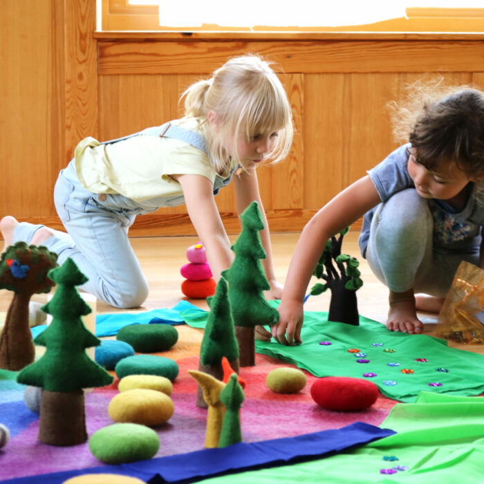 Kinder spielen mit Spielzeug aus Filz und Holz im Kindergarten