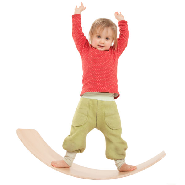 Kind balanciert auf dem Brett aus Holz