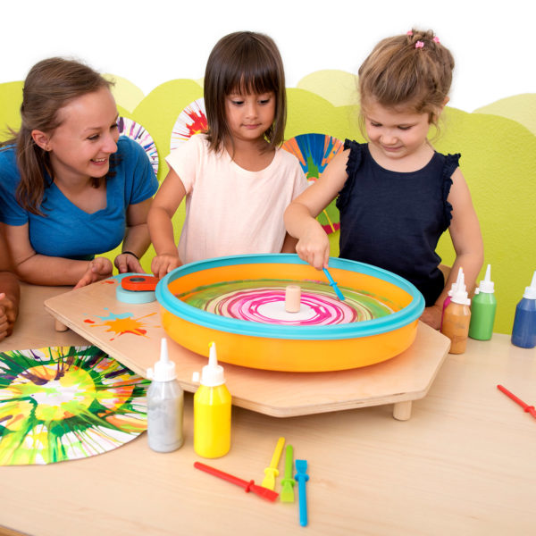 Kinder im Kindergartenalter kreiren mit der Farbschleuder und dem passenden Schaber individulle Kunstewerke