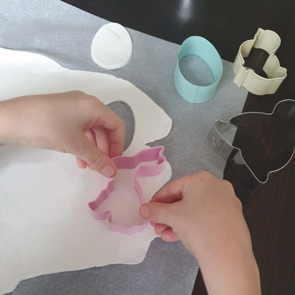 Kinder stechen Osteranhänger aus Modelliermasse aus