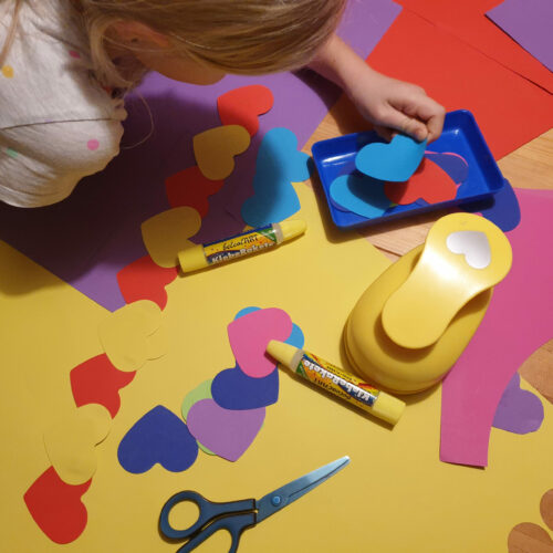 Kind bastelt mit gestanzten Herzen aus dem Riesen-Stanzer Herz