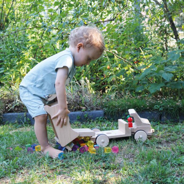 Kind spielt mit nic Großer Holzkipper