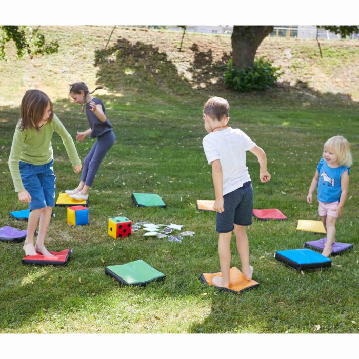 Kinder spielen mit Wahrnehmungskissen im Garten