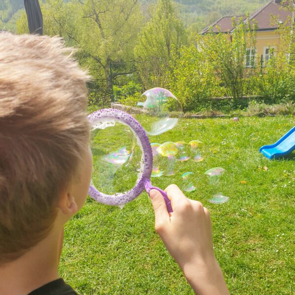 Kind macht Riesenseifenblasen
