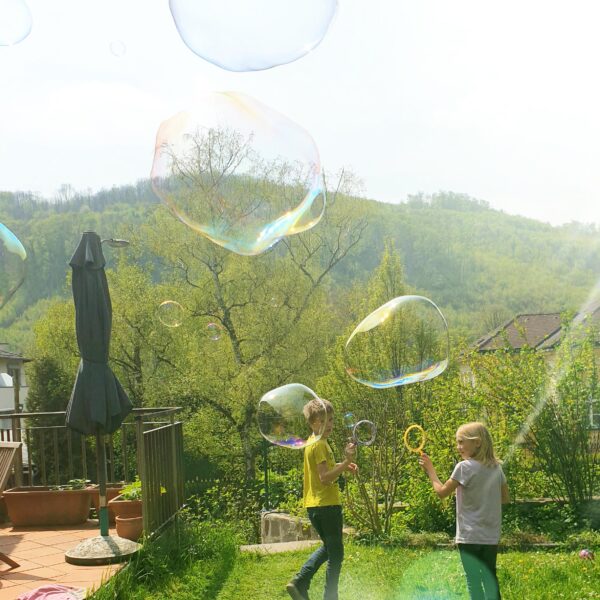 Kinder spielen mit Riesenseifenblasen