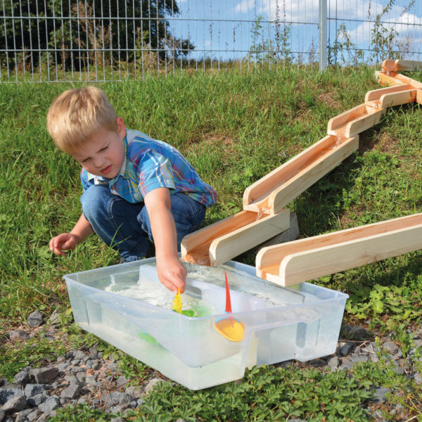 Kind spielt mit Wasserbahn aus Holz