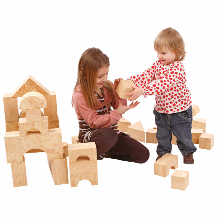 Mädchen im Kindergartenalter und Kind im Kleinkindalter spielen mit den weichen großen Softbausteinen in Holzoptik