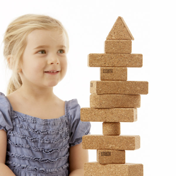 Kind baut mit Turm aus Korkbausteinen von KORXX