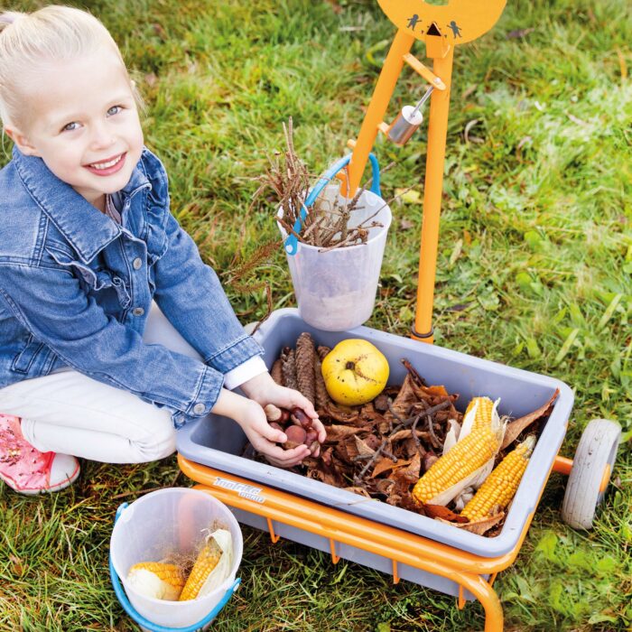 Kind wiegt Naturmaterialien mit der Toptrike Waage ab