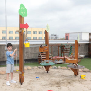 Kind spielt auf Sandspielanlage