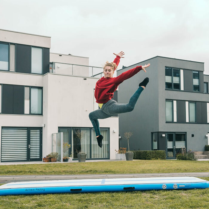 Frau turnt auf Airtrack Home blau