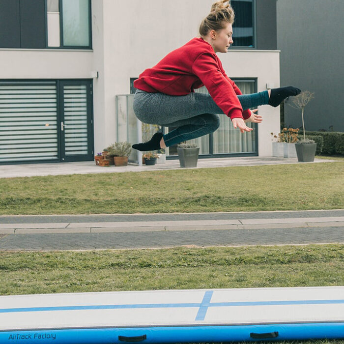 Frau turnt auf Airtrack Home blau