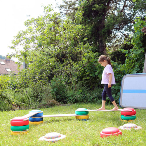 Kind balanciert auf Parcour Stapelsteinemti Balancebrücken Set