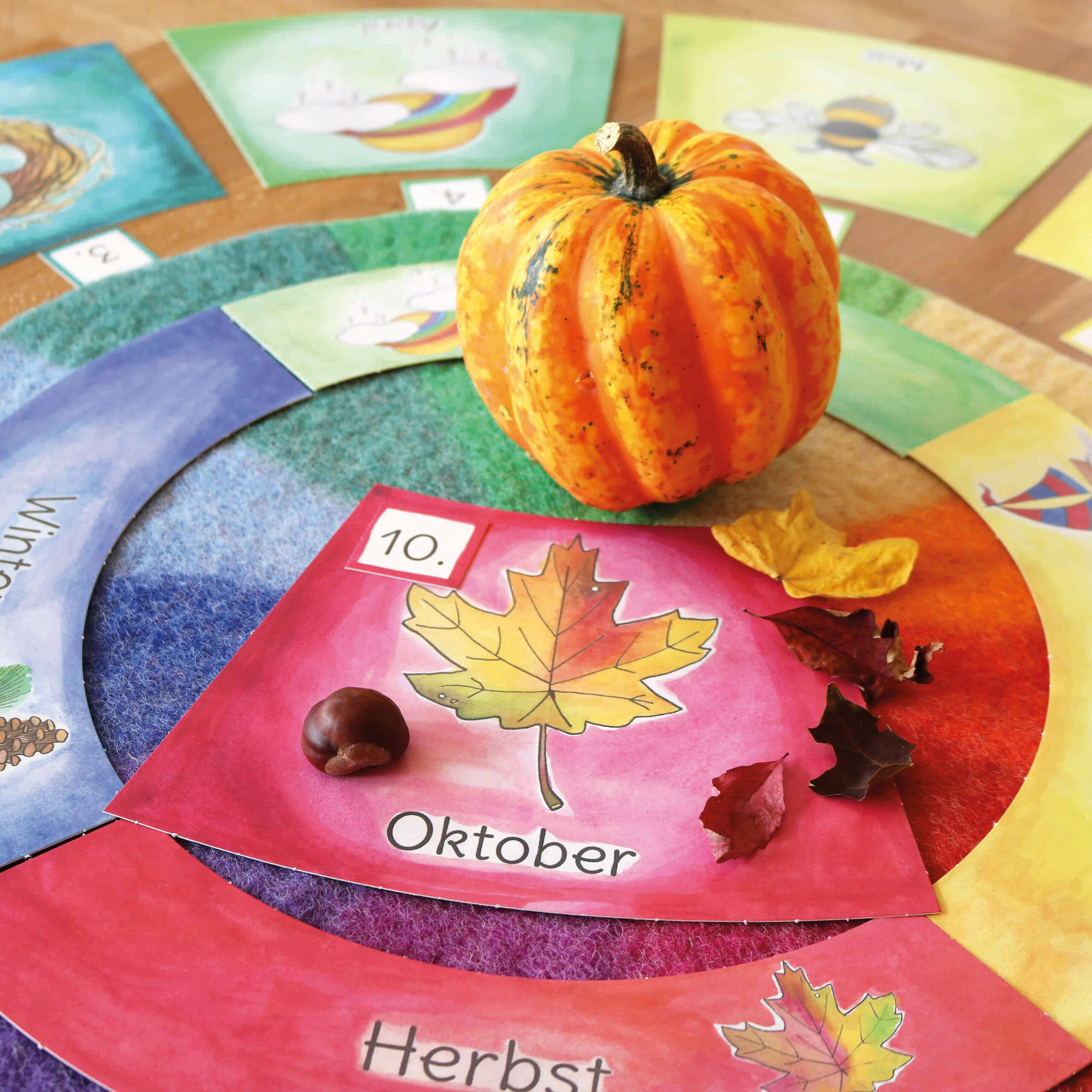 Herbstlicher Jahreszeitentisch im Kindergarten mit dem Farbenkreis und den Kalenderkarten