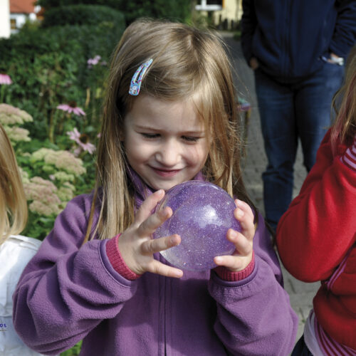 Kind spielt WASSERBALL Glitter